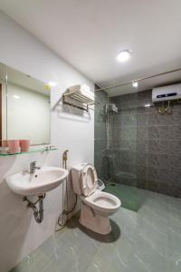 y baño con aseo, lavabo y ducha. en NM Homestay Danang, en Da Nang