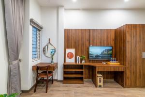 a home office with a desk and a television at NM Homestay Danang in Danang