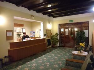 a woman standing at the counter of a salon at Hotel Narcyz in Świerad&oacute;w-Zdr&oacute;j