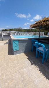 un banco azul y una silla junto a una piscina en Castaways Villa, en Duncans