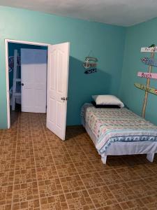 a bedroom with a bed and a blue wall at Castaways Villa in Duncans