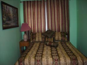 a bedroom with a bed and a lamp and a window at Deer trail Motel in Wisconsin Dells