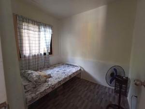 Kleines Zimmer mit einem Bett und einem Fenster in der Unterkunft Jodels Paradise in Ligao