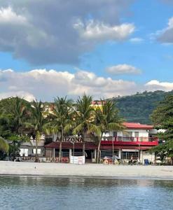 a building on the beach with palm trees and the water at ARIZONA BEACH RESORT in Olongapo