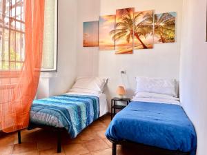 2 bedden in een kamer met palmbomen bij Casa Fiori D'Arancio in Levanto