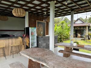 a patio with a table and a counter with chairs at The Lava Bali Villa and Hot Spring in Kintamani