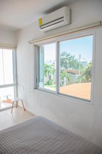 a bedroom with a large window and a bed at Casa privada con alberca grande in Chetumal