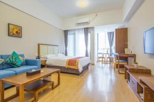 um quarto de hotel com uma cama e um sofá em Livetour Hotel Shenzhou Road Metro Guangzhou em Guangzhou