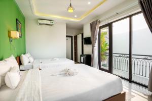 Habitación de hotel con 2 camas y balcón en HAI DAO HOI AN VILLA, en Hoi An