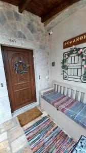 Habitación con puerta de madera y alfombra. en Rodanthe's Guest House, en Stemnitsa