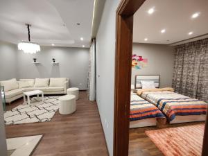 ein Schlafzimmer mit einem Bett und ein Wohnzimmer in der Unterkunft Luxury Duplexe in Beverly Hills in Sheikh Zayed