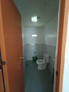 ein Bad mit einem WC, einem Fenster und einer Tür in der Unterkunft Jodels Paradise in Ligao