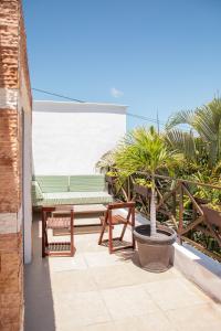 une terrasse avec un banc et un palmier dans l'établissement Casa privada con alberca grande, à Chetumal
