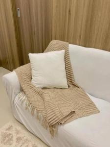 uma cama com um cobertor e uma almofada em Cozy 1 BR Condo in Fame Residences Mandaluyong City em Manila