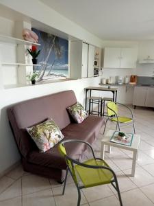 sala de estar con sofá, sillas y mesa en F2 proche plage Anse Mitan en Les Trois-Îlets
