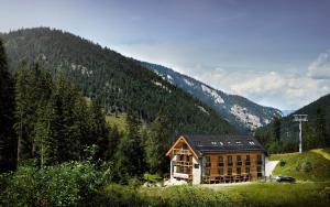 a house on the side of a hill with a mountain at Apartmany Demänovka Jasna in Belá