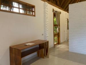 einen Holzschreibtisch in einem Zimmer mit Fenster in der Unterkunft Hotel La Costa International in Puerto López