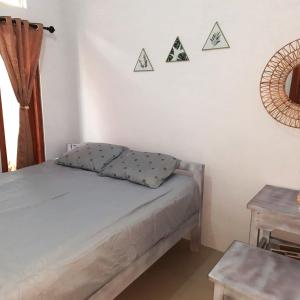 a small bedroom with a bed and a table at rindoe jogja holiday home in Yogyakarta