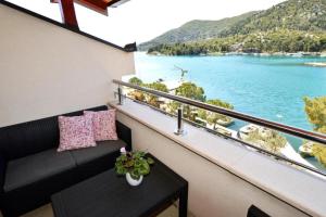 d'un balcon avec un canapé et une vue sur l'eau. dans l'établissement Apartment Leo - sea view & comfortable, à Ploče