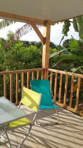 a yellow and blue chair sitting on a deck at F2 proche plage Anse Mitan in Les Trois-Îlets