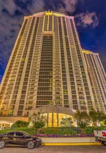 a large building with a car parked in front of it at Balcony Suite Strip View in Las Vegas