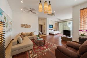 un salon avec un canapé et une télévision dans l'établissement The Luxe Bali - Luxury 4 Bedroom Cliff Ocean Edge Villa Uluwatu, à Uluwatu