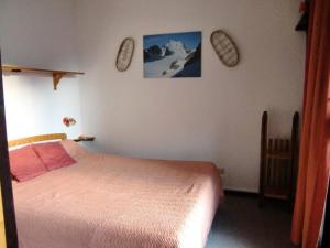 ChampsellaにあるRésidence Les Mélèzes 61496のベッドルーム1室(ベッド1台付)が備わります。壁に2枚の写真が飾られています。