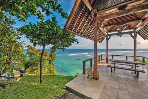 un banc sous un pavillon surplombant l'océan dans l'établissement The Luxe Bali - Luxury 4 Bedroom Cliff Ocean Edge Villa Uluwatu, à Uluwatu