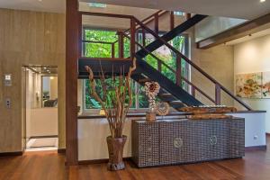 un hall avec un escalier et un vase avec une plante dans l'établissement The Luxe Bali - Luxury 4 Bedroom Cliff Ocean Edge Villa Uluwatu, à Uluwatu