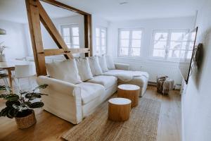 sala de estar con sofá blanco y taburetes de madera en Fritz im Glück en Rietberg