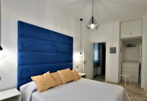 a bed with a blue headboard in a room at La Villa di Nonna Pina in Balestrate