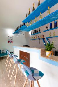 un bar con estanterías y taburetes azules en Agua Dorada Boutique en Lula