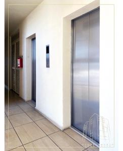 un couloir avec une porte métallique dans un bâtiment dans l'établissement Departamento Loma-Alta, à Guadalajara