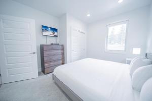 a white bedroom with a white bed and a window at Clearwater Lofts Bldg 3 103 in Keystone