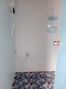 a bathroom with a shower with a tiled floor at Titanic's Nipa Hut in Moalboal