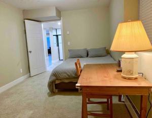 een slaapkamer met een bed en een tafel met een lamp bij Cozy Home Nestled in Burke Mountain. in Coquitlam
