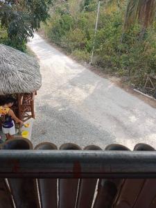 un niño pequeño jugando con un juguete en un camino en Titanic's Nipa Hut en Moalboal