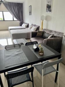 a living room with a table and a couch at Cozy Studio Sk 1 Residence for 4 pax UPM Mines Serdang in Seri Kembangan
