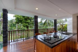 a kitchen with a balcony with a counter and a stove at Kelusa Hill in Ubud