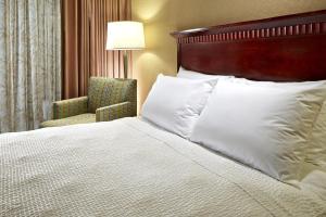 アナハイムにあるポルトフィーノ イン ＆ スイーツ アナハイム ホテルのベッドと椅子付きのホテルルーム