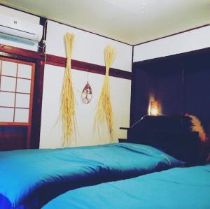 Un dormitorio con una cama azul y una ventana en Hi-COLOR handworks, en Hiura