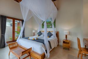 a bedroom with a bed with a canopy at Kelusa Hill in Ubud