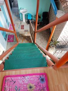 Elle offre une vue sur un escalier doté d'un tapis vert. dans l'établissement Titanic's Nipa Hut, à Moalboal