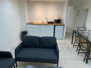 salon z kanapą i kuchnią w obiekcie Appartement 2ème étage 42m2 hyper centre ville / parking gratuit w mieście Riom