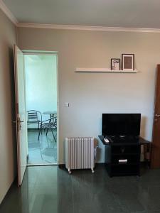 een woonkamer met een televisie en een tafel met stoelen bij Sunny in Haskovo