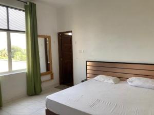 a bedroom with a large bed and a window at Sycamore Residences in Mount Lavinia