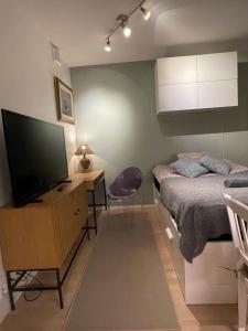 um quarto com uma cama e uma secretária com uma televisão em The Seaside Apartment Turku em Turku