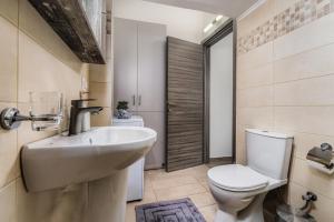 ein Badezimmer mit weißer Toilette und Waschbecken in der Unterkunft Little Gem in Zakynthos