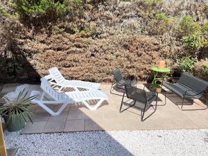 a patio with two chairs and a table and two chairs at Camping le lac des rêves L'ABRIZEN in Lattes