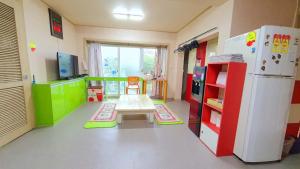 a room with a refrigerator and a table in it at Happy Garden Guesthouse in Seoul